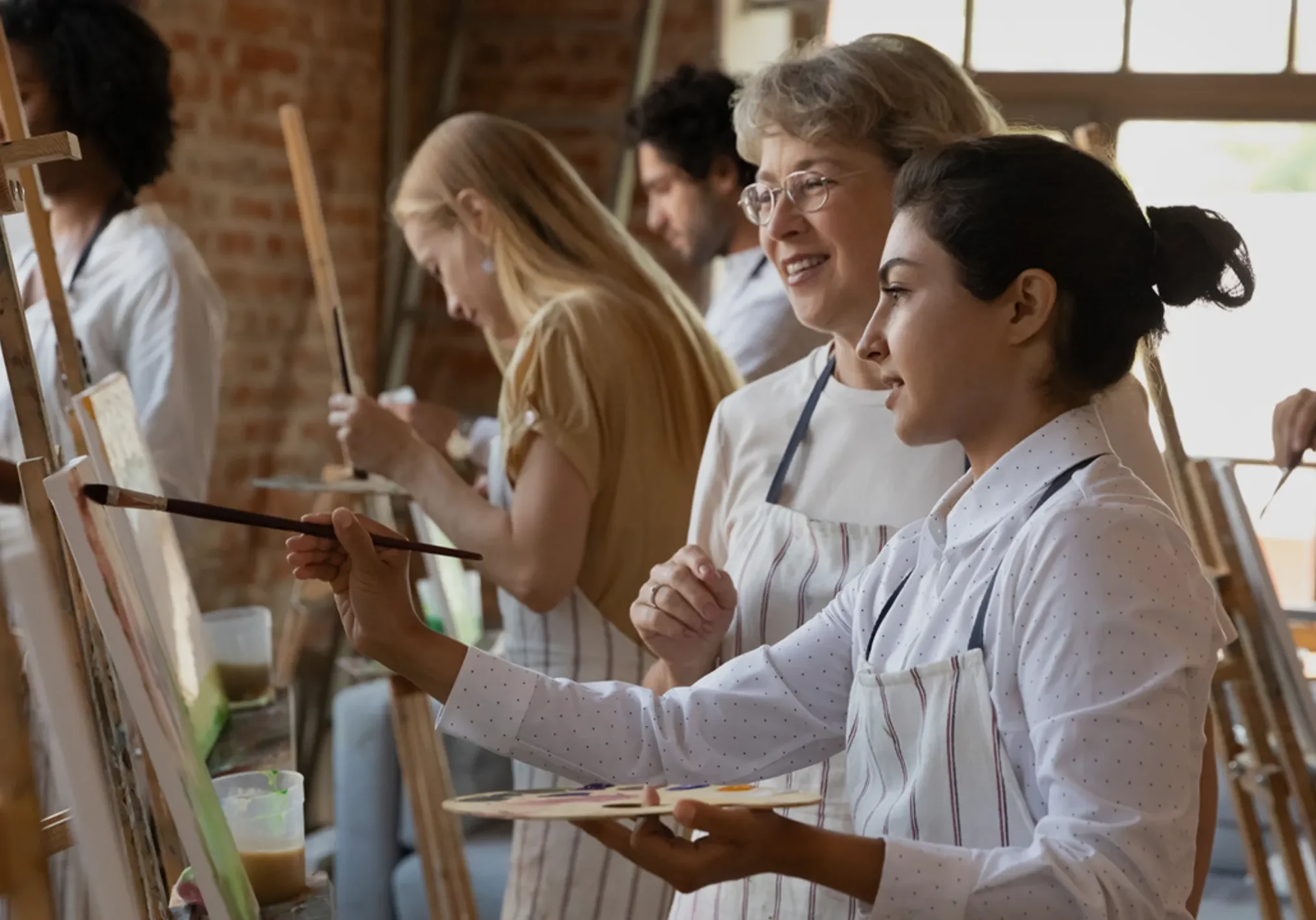 Art class instructor guiding student painting