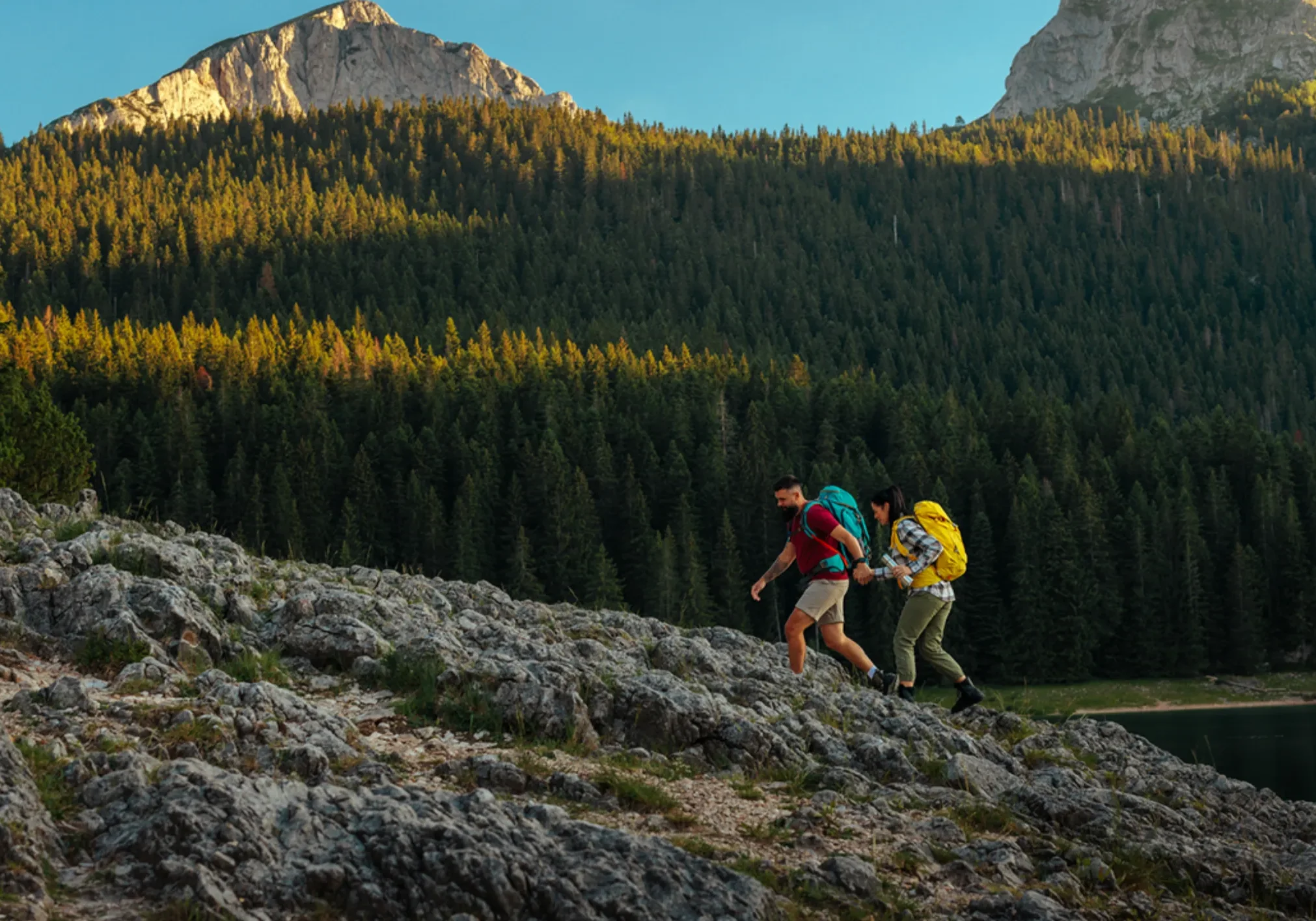 Two hikers with backpacks on rocky trail